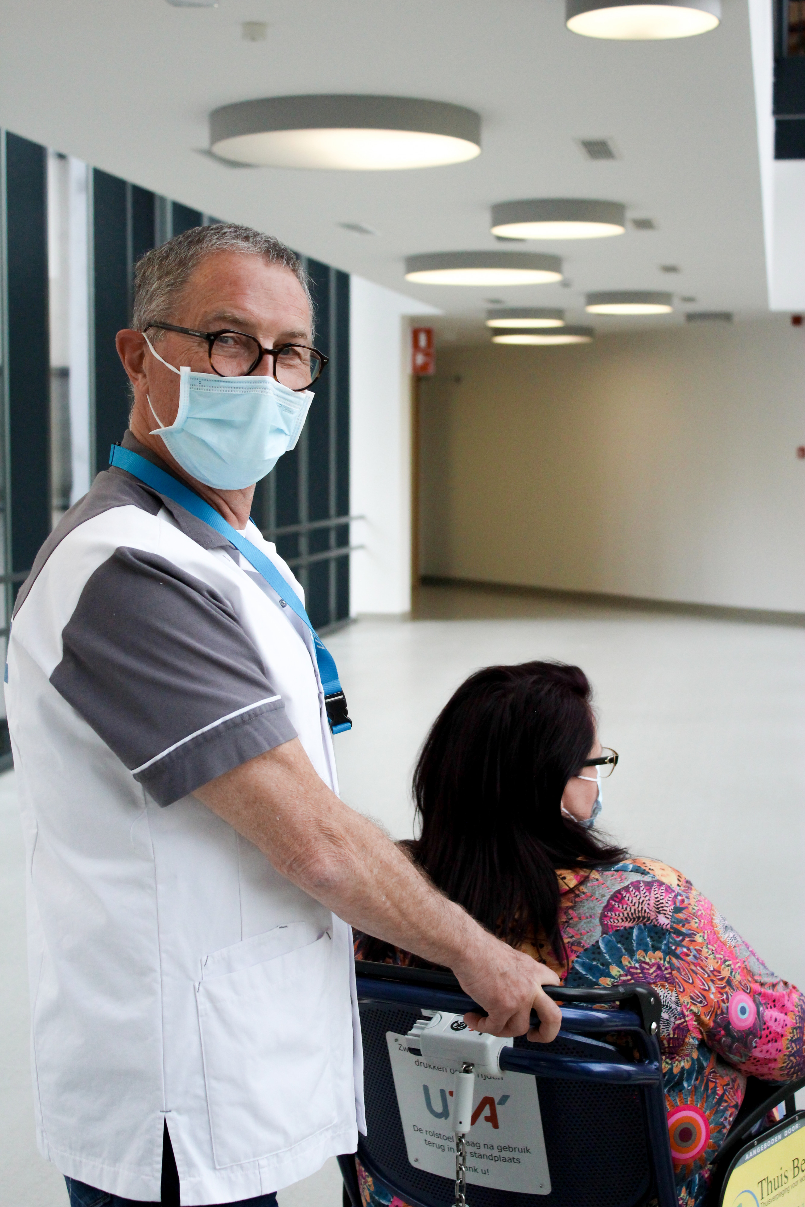 vrijwilligers luc brengt patiënt naar de kamer