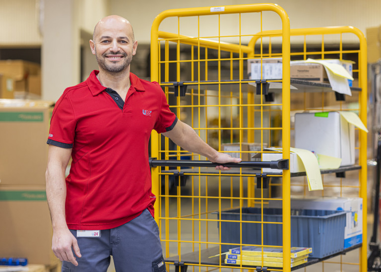 Magazijnier trekt een kar vooruit met materiaal