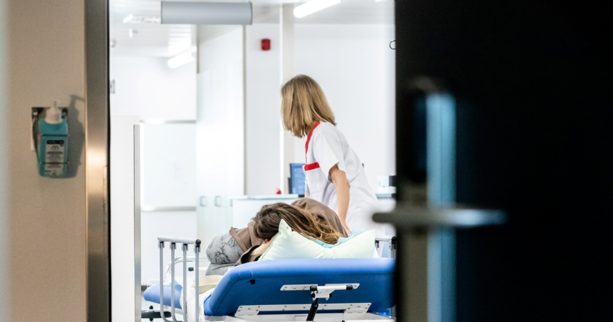 Verpleegkundige rijdt met bed 