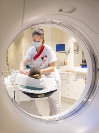 Verpleegkundige legt een patiënt klaar op de scan