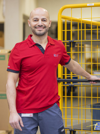 Magazijnier trekt een kar vooruit met materiaal